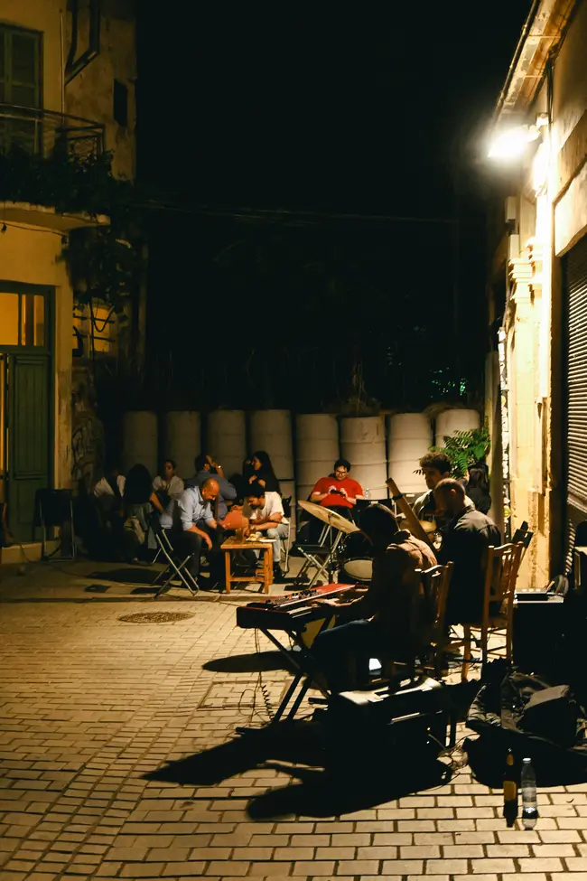 Κάτοικοι της πόλης απολαμβάνουν την σχεδόν καλοκαιρινή βραδιά, ενώ πίσω τους βρίσκονται τα σύρματα της νεκρής ζώνης.